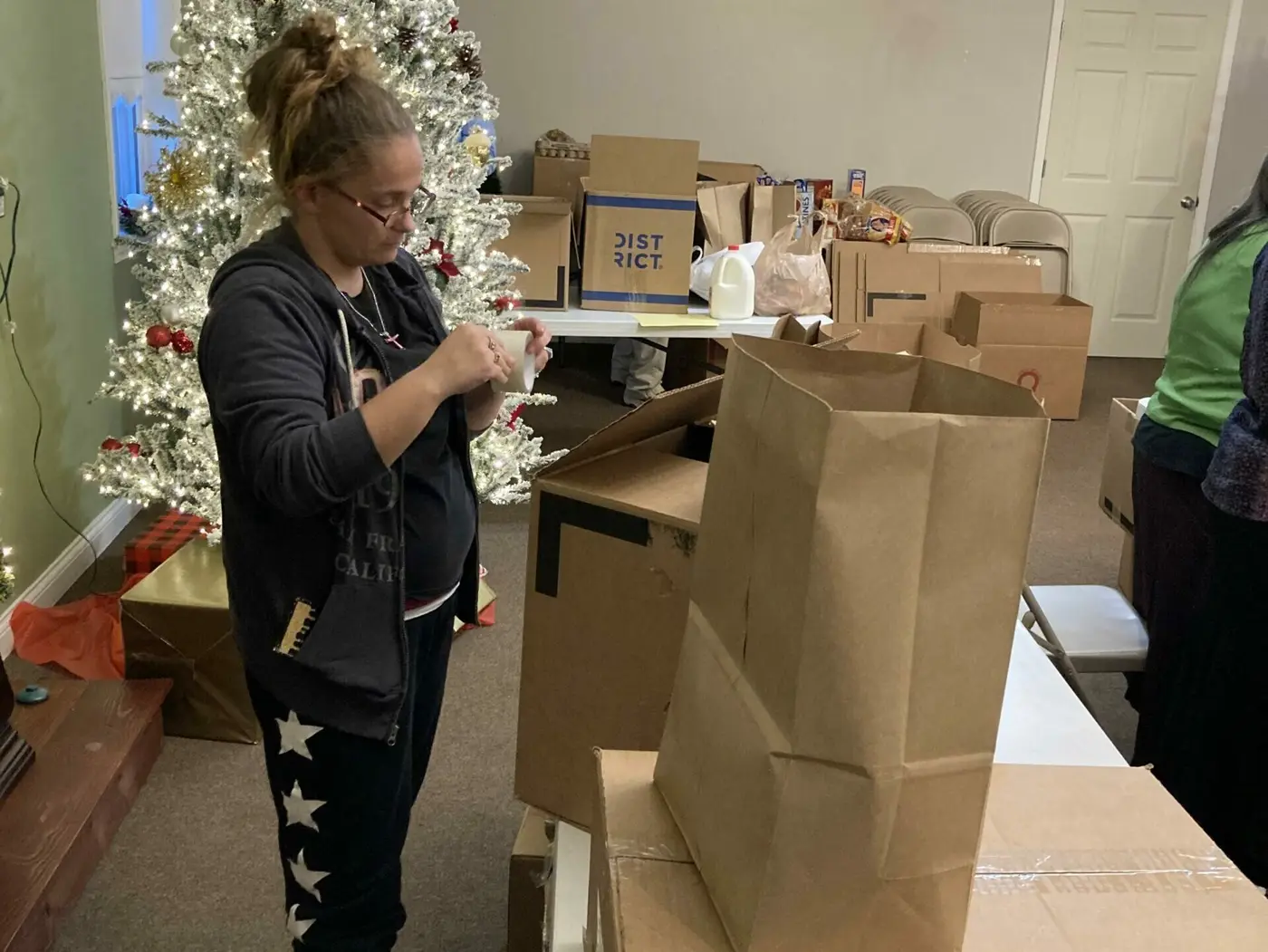 Volunteers smiling while packing holiday food boxes