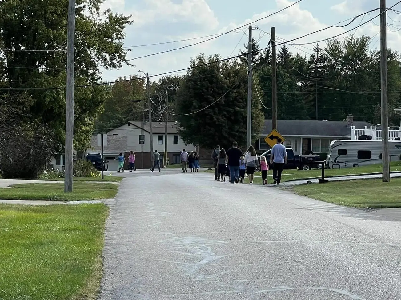 Church members walking a neighborhood street in Rushville